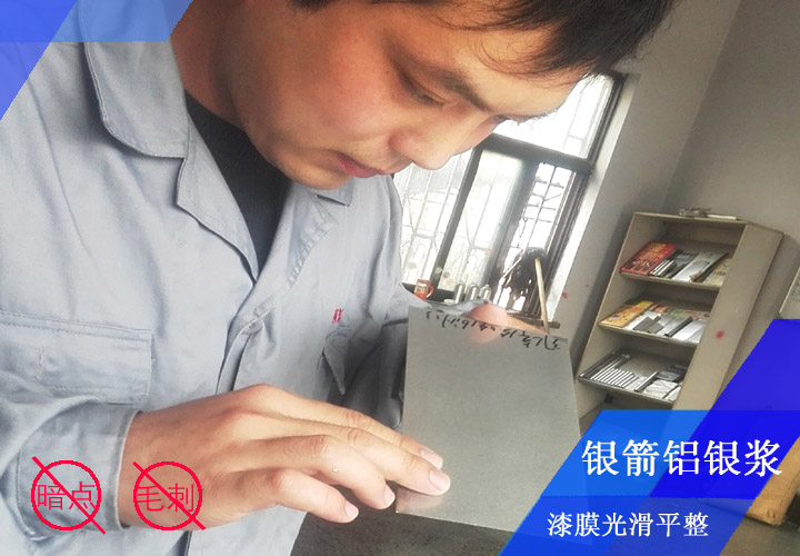 銀箭鋁銀漿工程師李工正在對(duì)發(fā)動(dòng)機(jī)殼烤漆漆膜看板檢測(cè)，確保漆膜光滑平整無(wú)暗點(diǎn)、無(wú)毛刺
